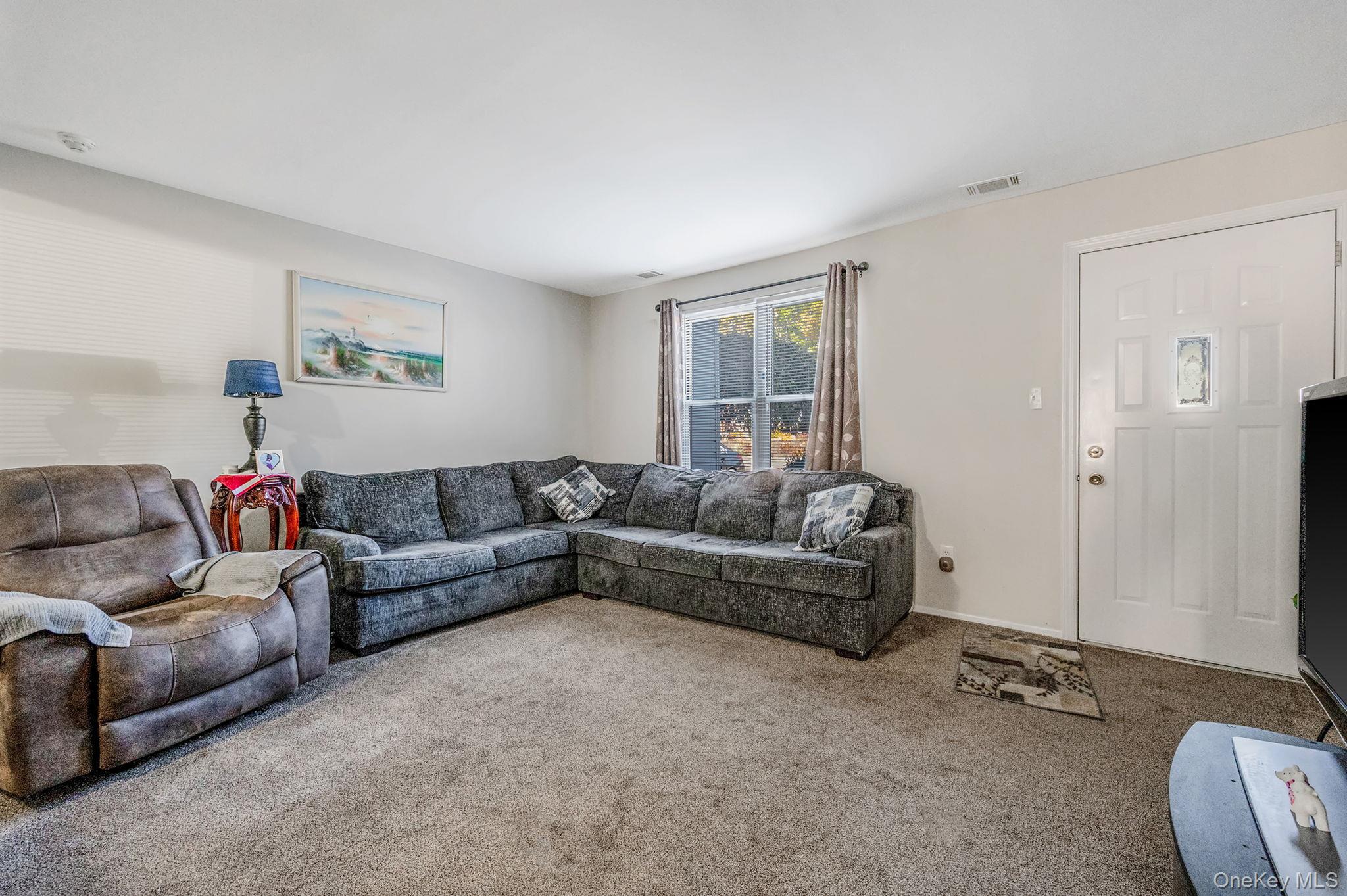 63 Rocky Point Yaphank Road, Unit 80 Rocky Point, NY 11778 - Photo 4 of 25 Living area featuring carpet flooring