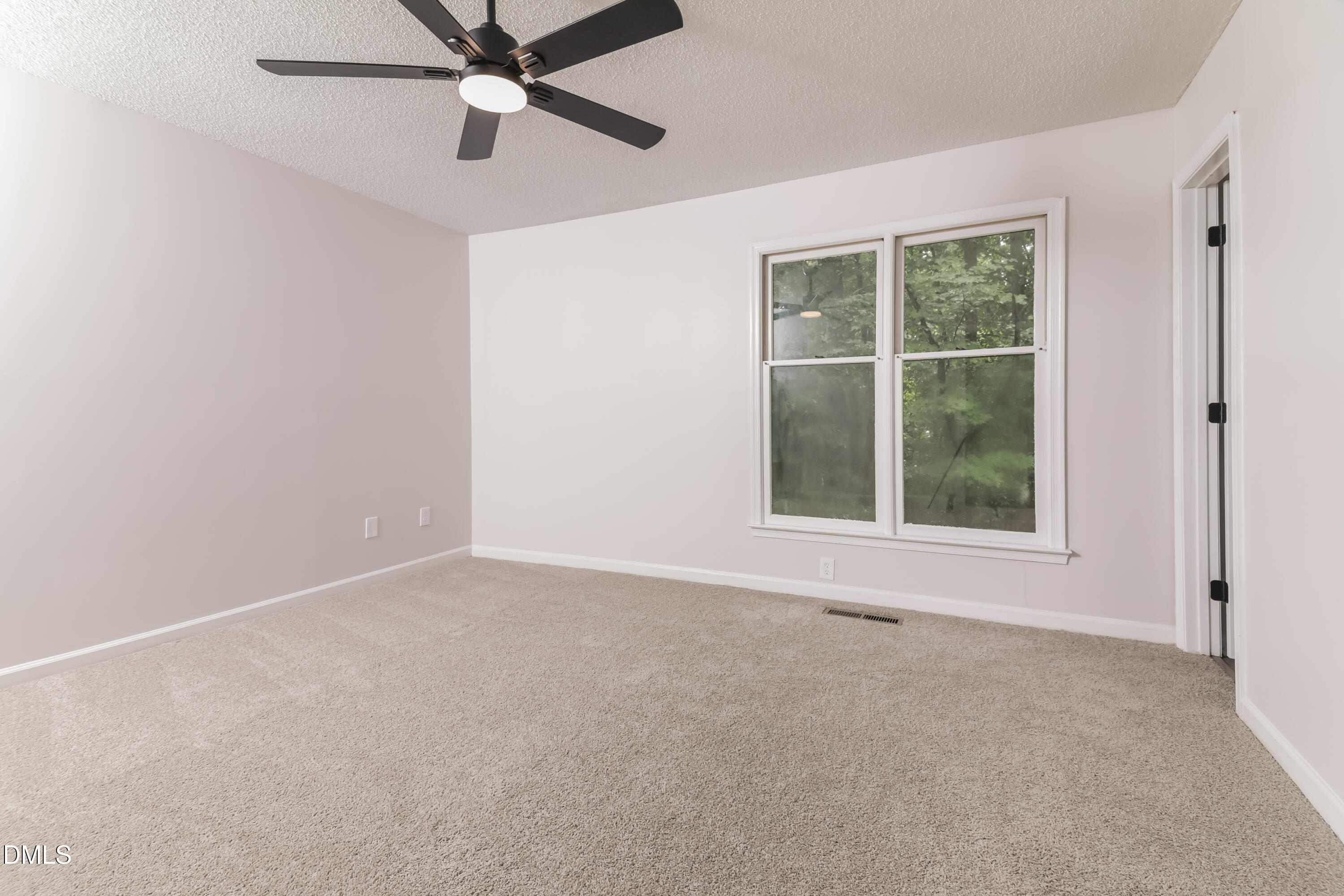6 Fircrest Court Durham, NC 27703 - Photo 8 of 15 an empty room with a window and a ceiling fan