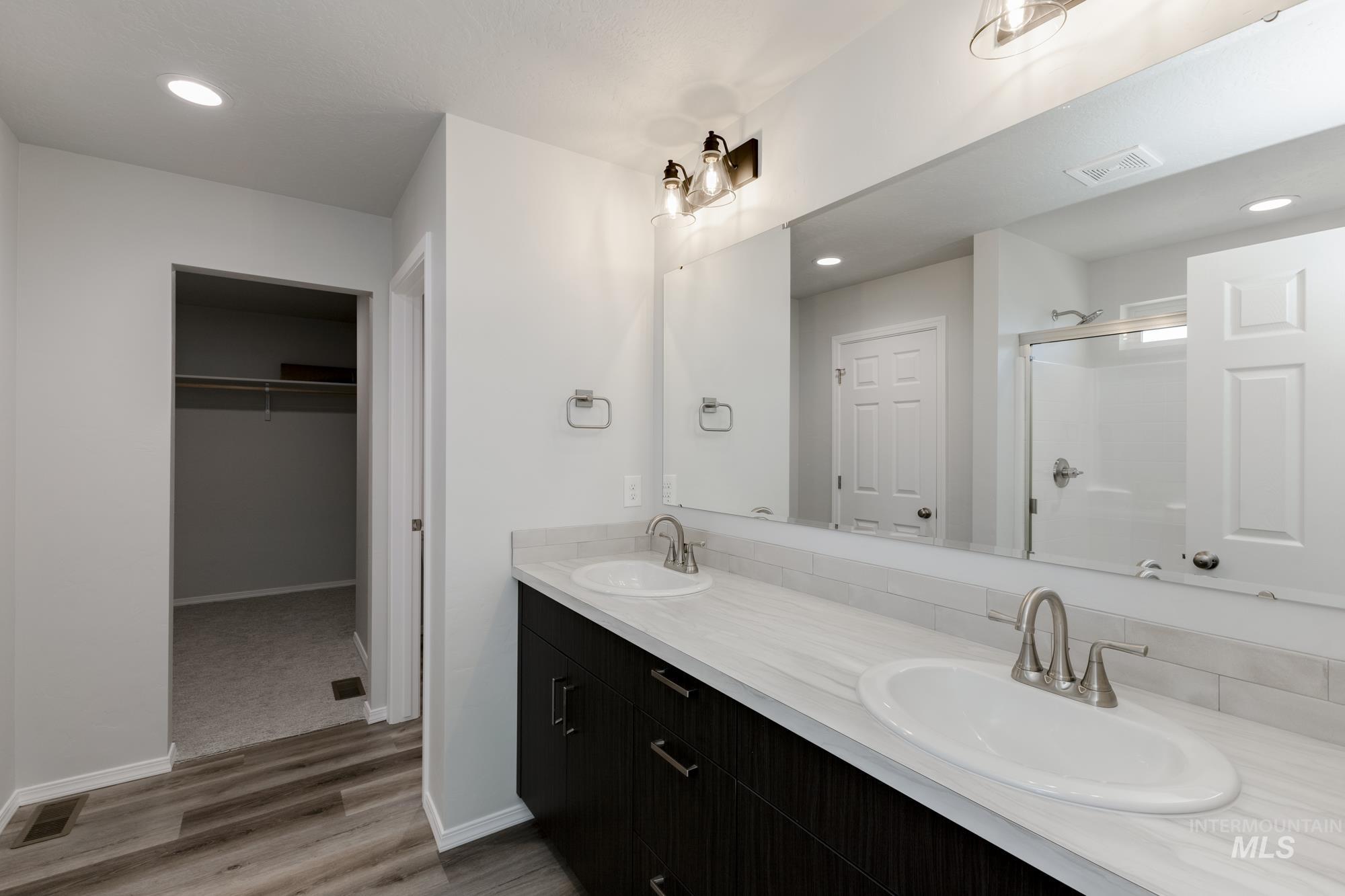 3270 South Maple Rnch Way Nampa, ID 83686 - Photo 29 of 31 Bathroom featuring recessed lighting, double vanity, a shower stall, a walk in closet, and light wood-type flooring
