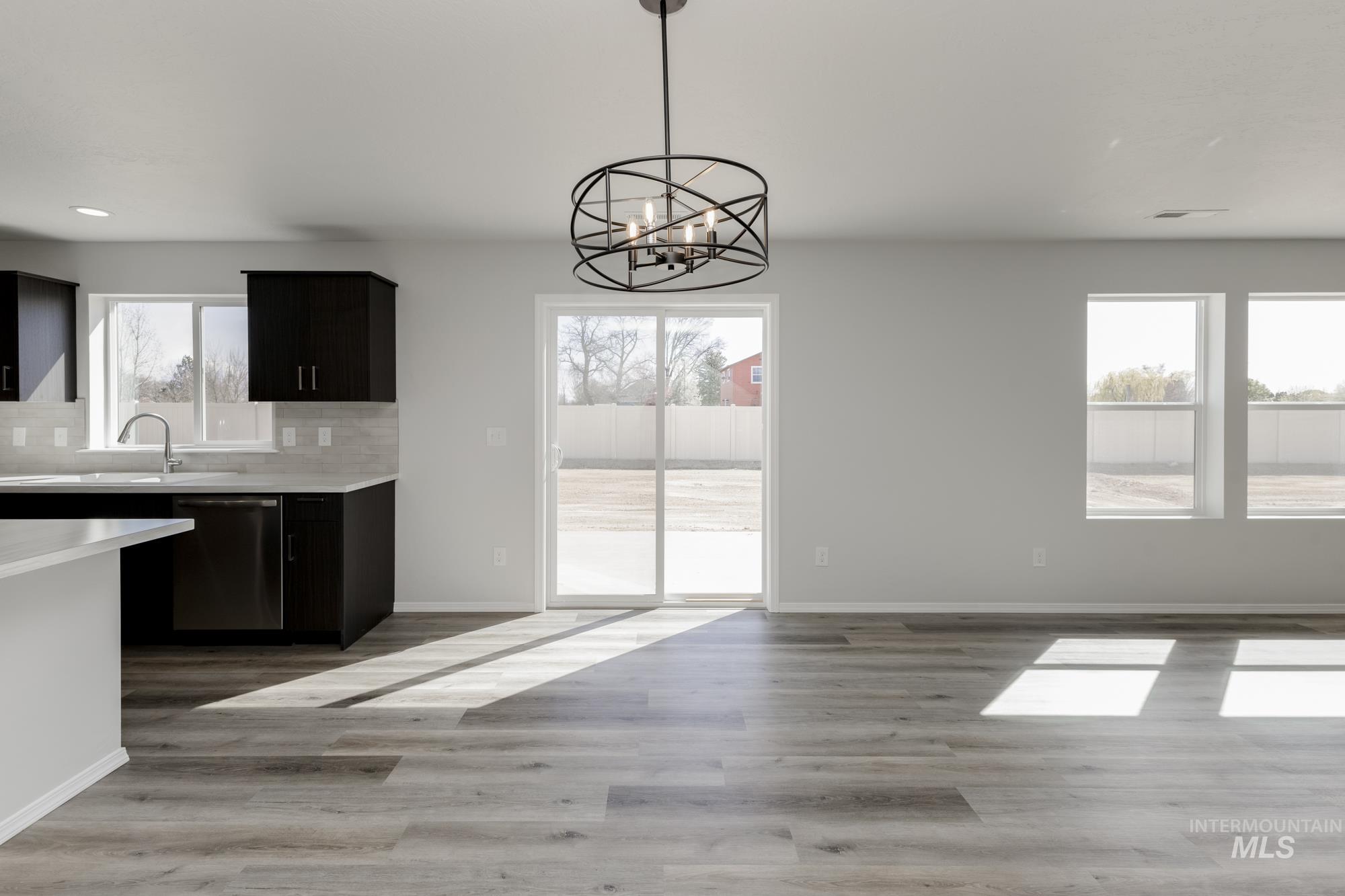 3270 South Maple Rnch Way Nampa, ID 83686 - Photo 7 of 31 Kitchen with light countertops, pendant lighting, tasteful backsplash, stainless steel dishwasher, and light wood finished floors