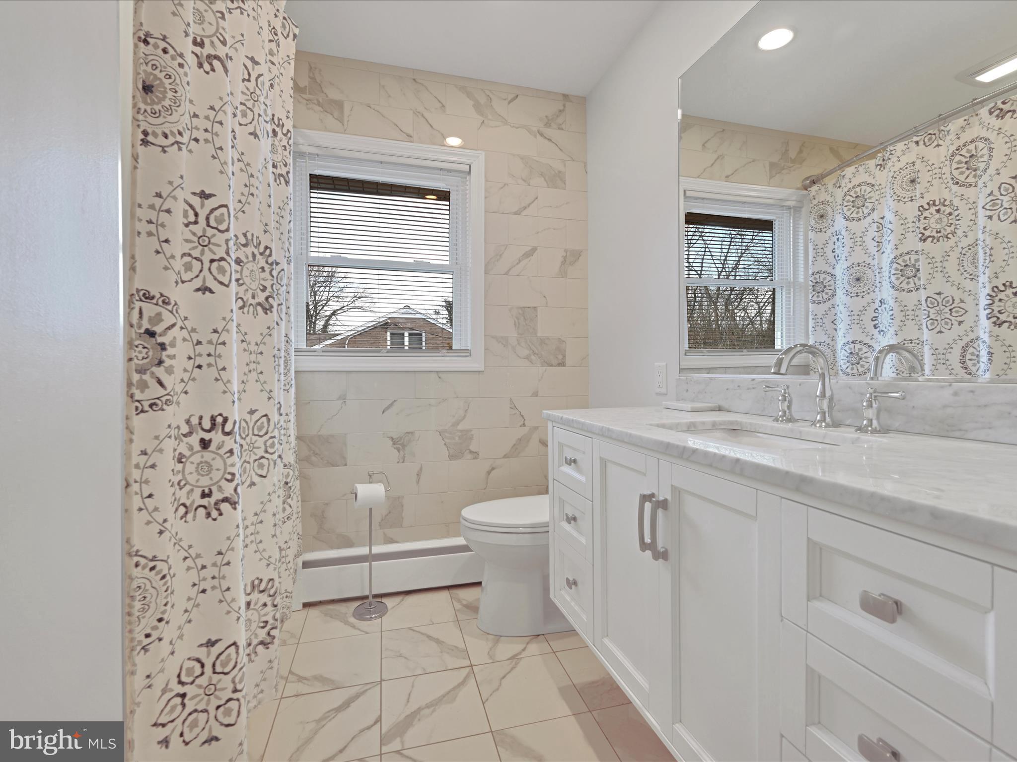 4500 Channing Road Wilmington, DE 19802 - Photo 22 of 35 a bathroom with a granite countertop toilet a sink and a mirror
