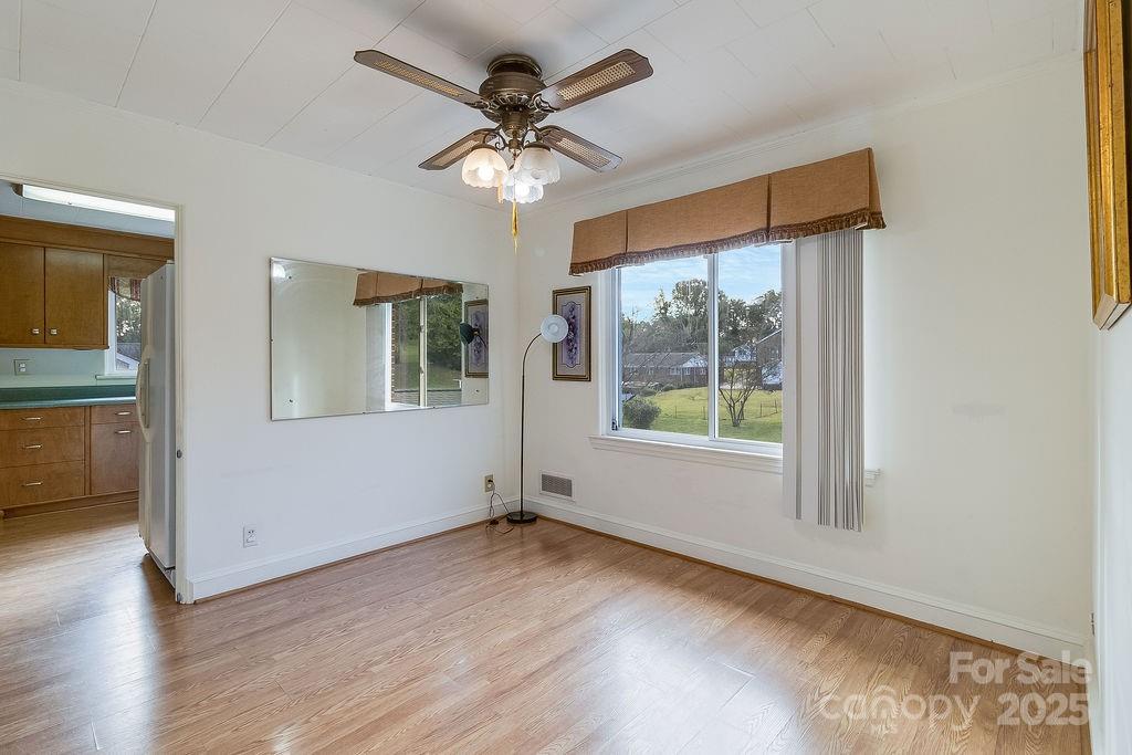 209 Park Street Morganton, NC 28655 - Photo 15 of 35 an empty room with wooden floor fan and windows