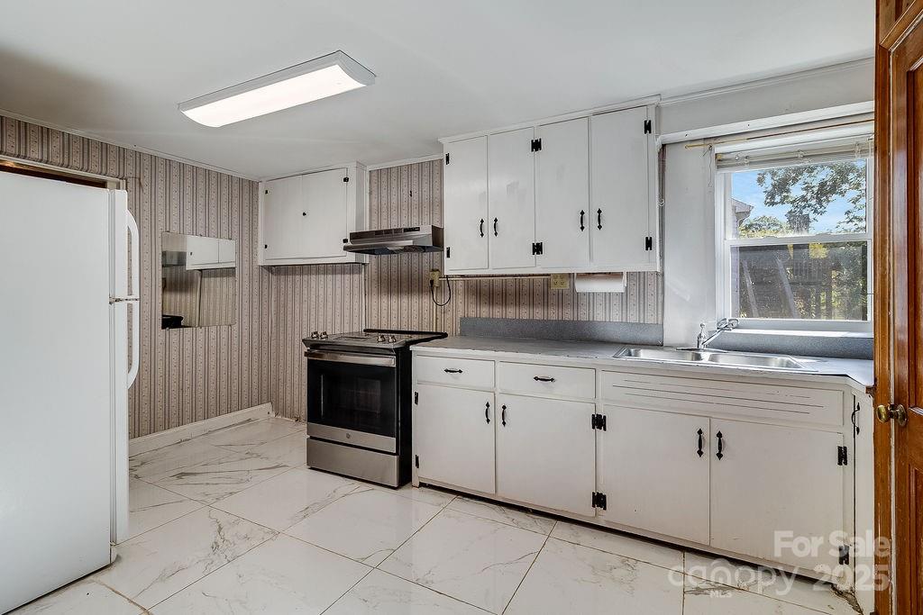 209 Park Street Morganton, NC 28655 - Photo 25 of 35 a kitchen with stainless steel appliances granite countertop a stove a sink and a refrigerator