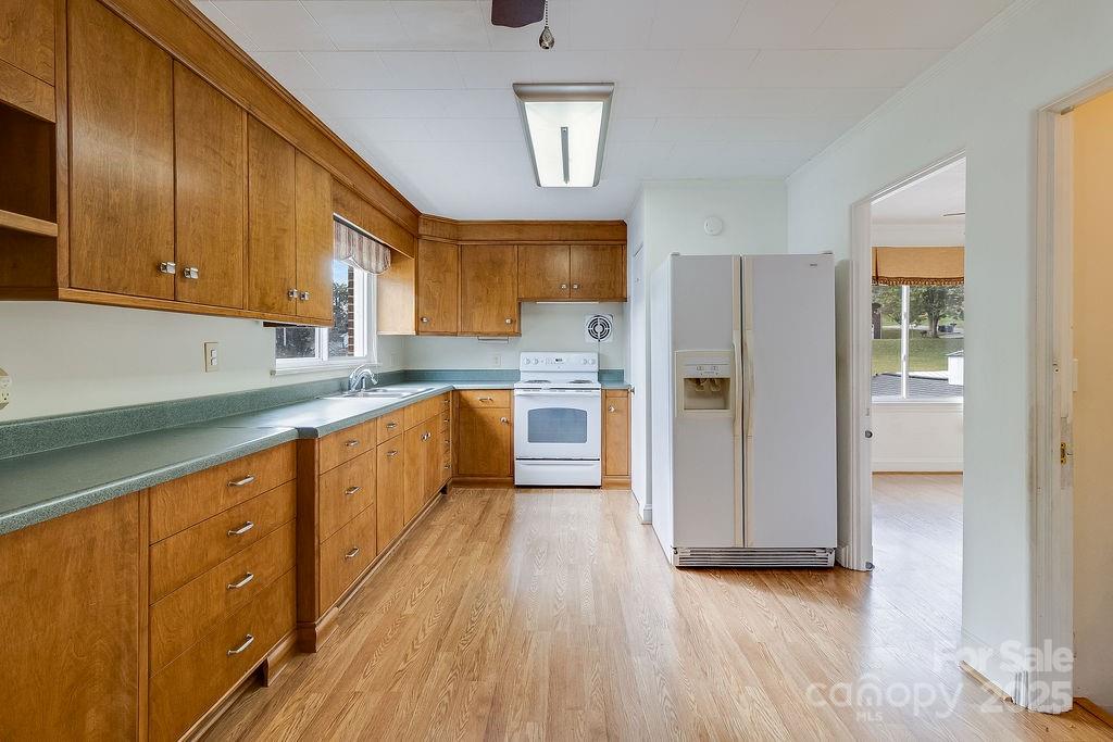 209 Park Street Morganton, NC 28655 - Photo 8 of 35 a large kitchen with stainless steel appliances granite countertop a refrigerator a sink dishwasher and wooden cabinets with wooden floor