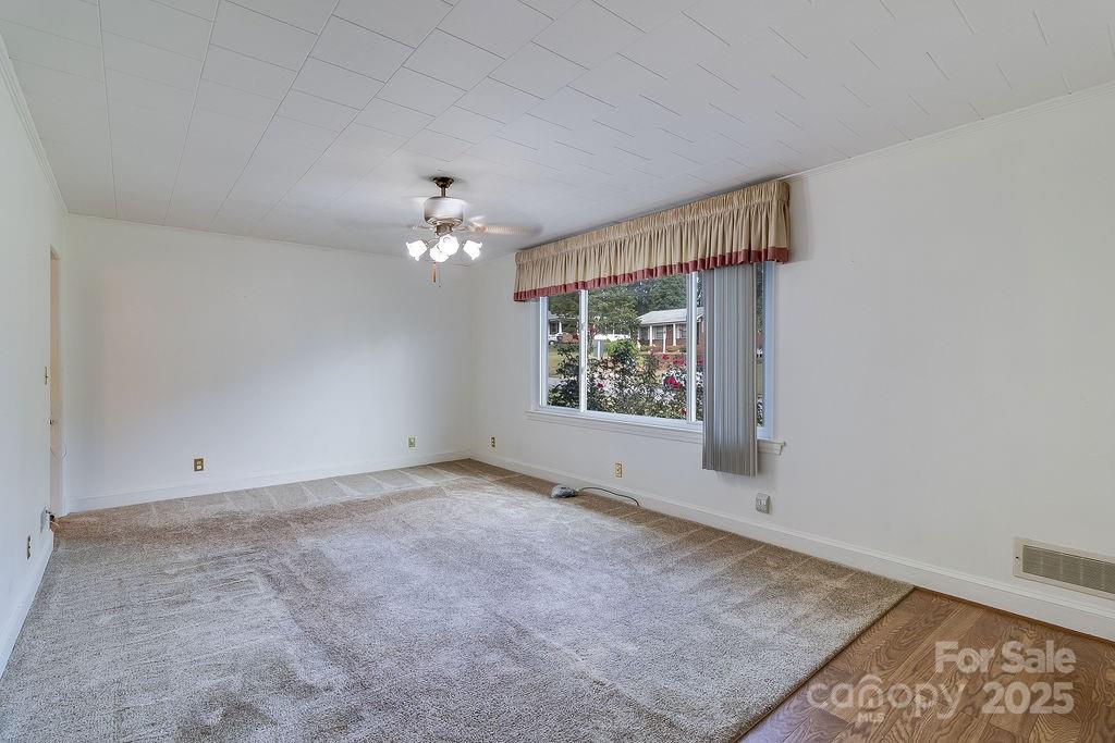 209 Park Street Morganton, NC 28655 - Photo 9 of 35 an empty room with windows and chandelier fan