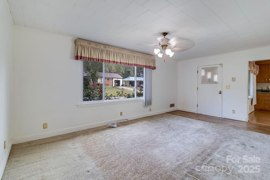 209 Park Street Morganton, NC 28655 - Photo 10 of 35 a view of a big room with chandelier fan and windows