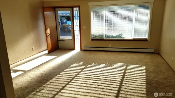 a view of a livingroom with wooden floor and a large window