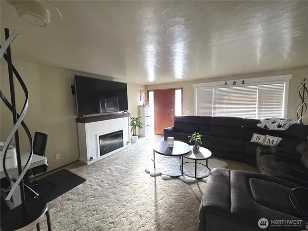 a living room with furniture a fireplace and a flat screen tv
