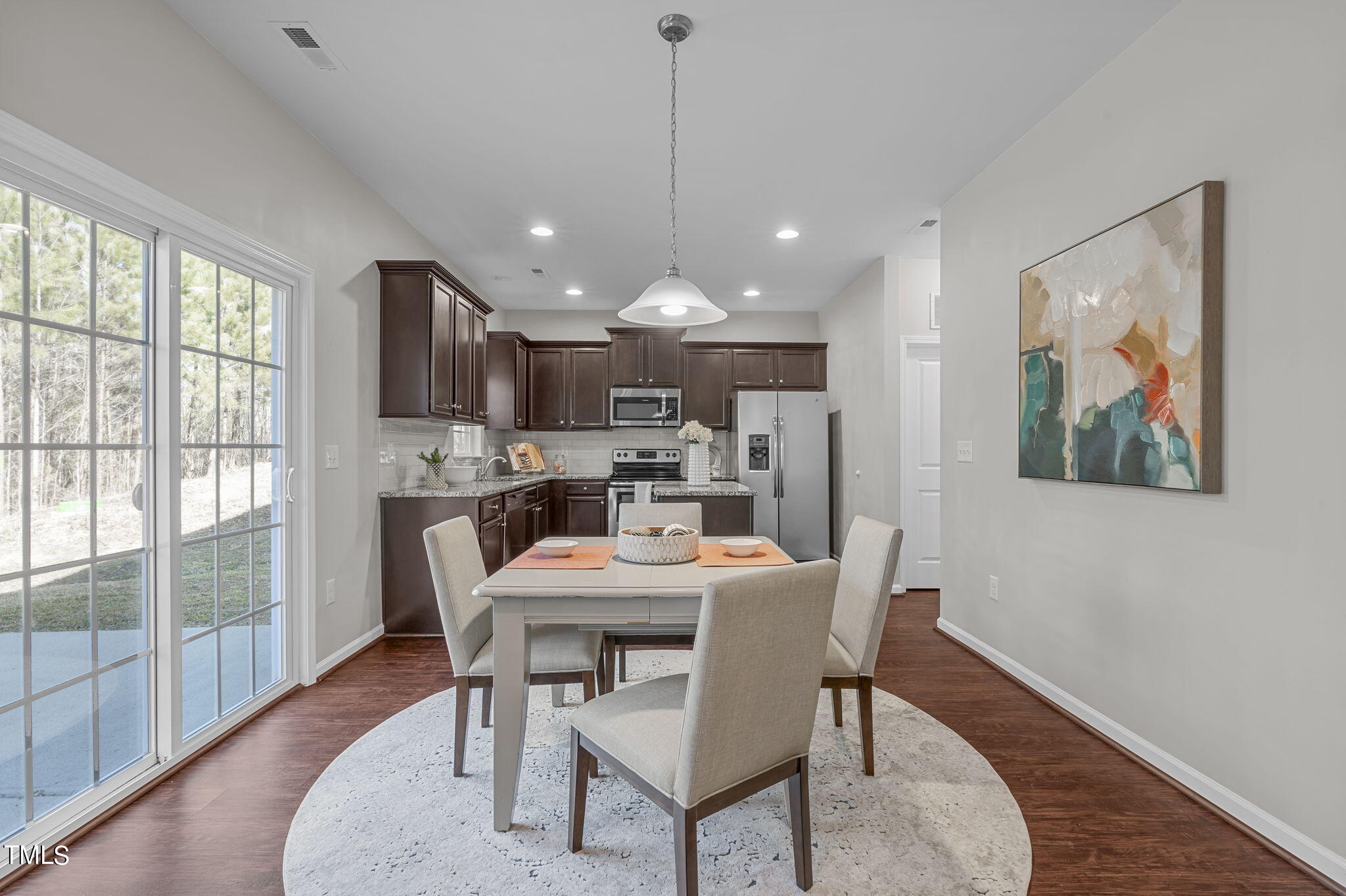 3652 Tule Spring Street Raleigh, NC 27610 - Photo 18 of 51 a dining room with furniture a rug a painting and a chandelier
