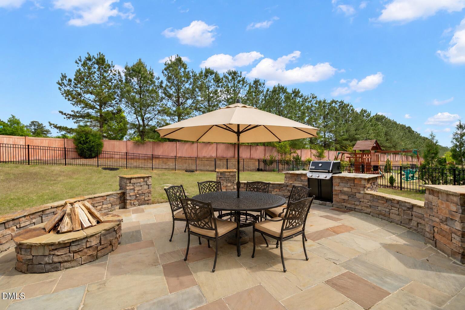 364 Springtime Fields Lane Wake Forest, NC 27587 - Photo 51 of 63 a view of a patio with a table and chairs under an umbrella