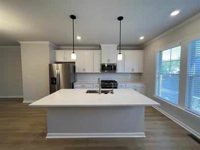 2267 Graywell Lane Duluth, GA 30096 - Photo 7 of 26 a large kitchen with stainless steel appliances a large kitchen island a stove a refrigerator a center island a stove and wooden floor