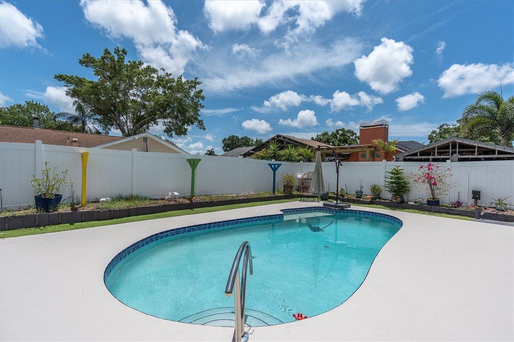 12107 72nd Way Largo, FL 33773 - Photo 32 of 40 a view of a swimming pool with a yard and plants