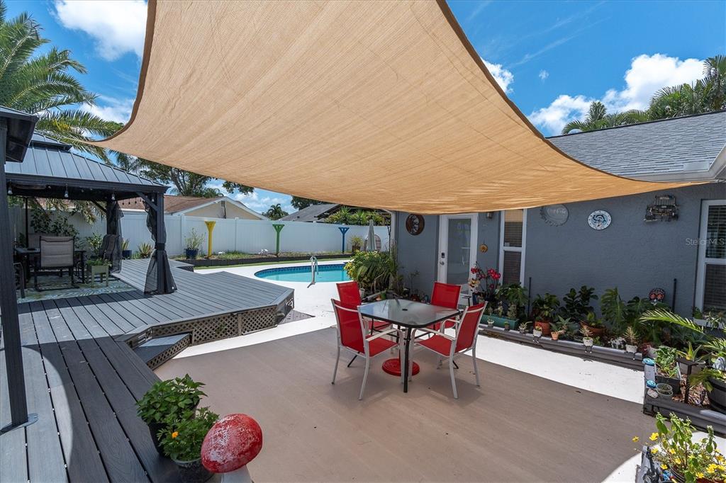 12107 72nd Way Largo, FL 33773 - Photo 35 of 40 a view of a patio with table and chairs potted plants with wooden floor