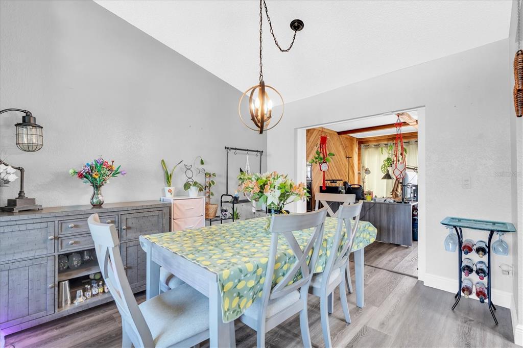 12107 72nd Way Largo, FL 33773 - Photo 8 of 40 a dining room with furniture potted plants and wooden floor