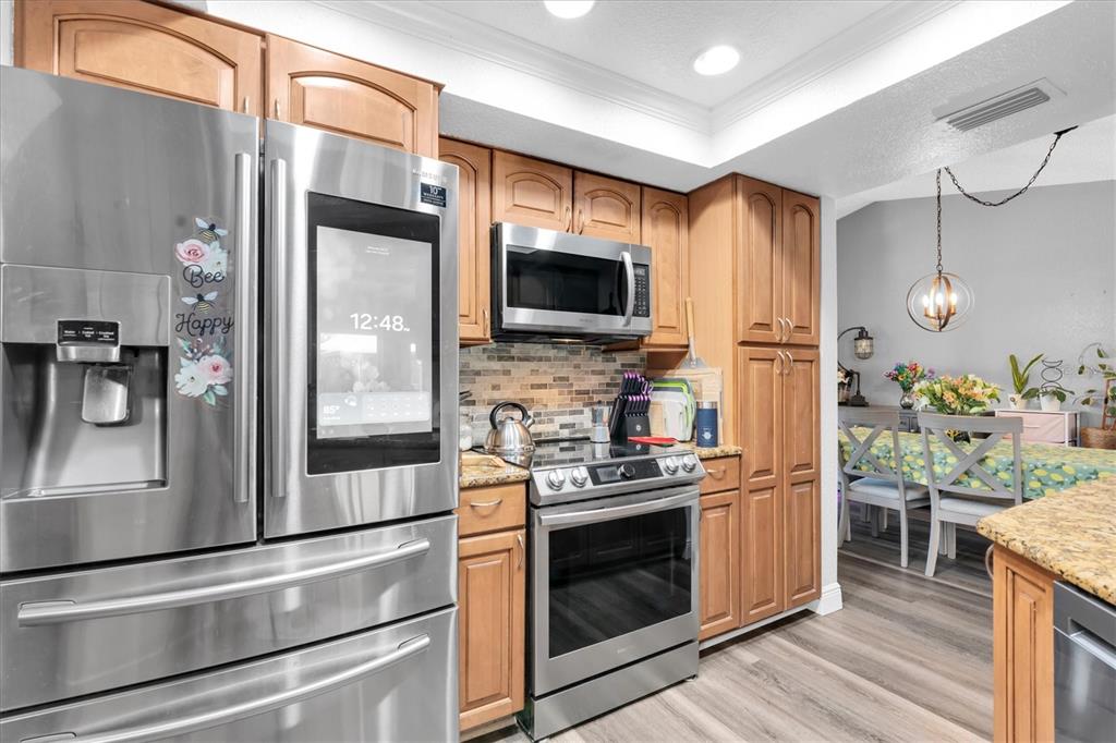 12107 72nd Way Largo, FL 33773 - Photo 10 of 40 a kitchen with stainless steel appliances a refrigerator a stove and a sink