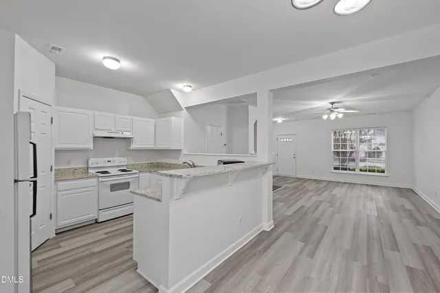 a kitchen with stainless steel appliances a stove top oven a sink dishwasher and a refrigerator