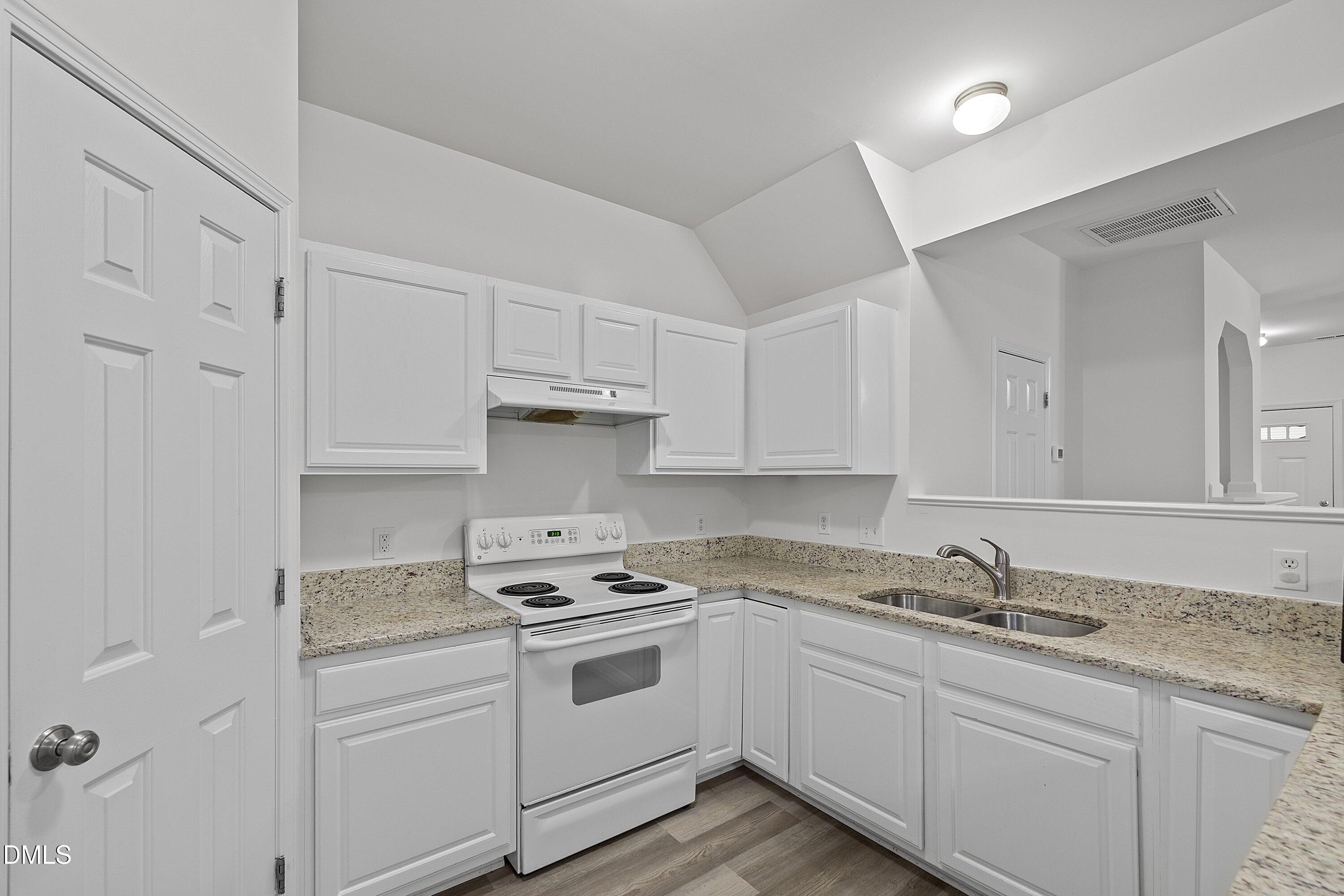 8321 Glenwood Springs Court Raleigh, NC 27616 - Photo 17 of 37 a kitchen with granite countertop white cabinets and white appliances