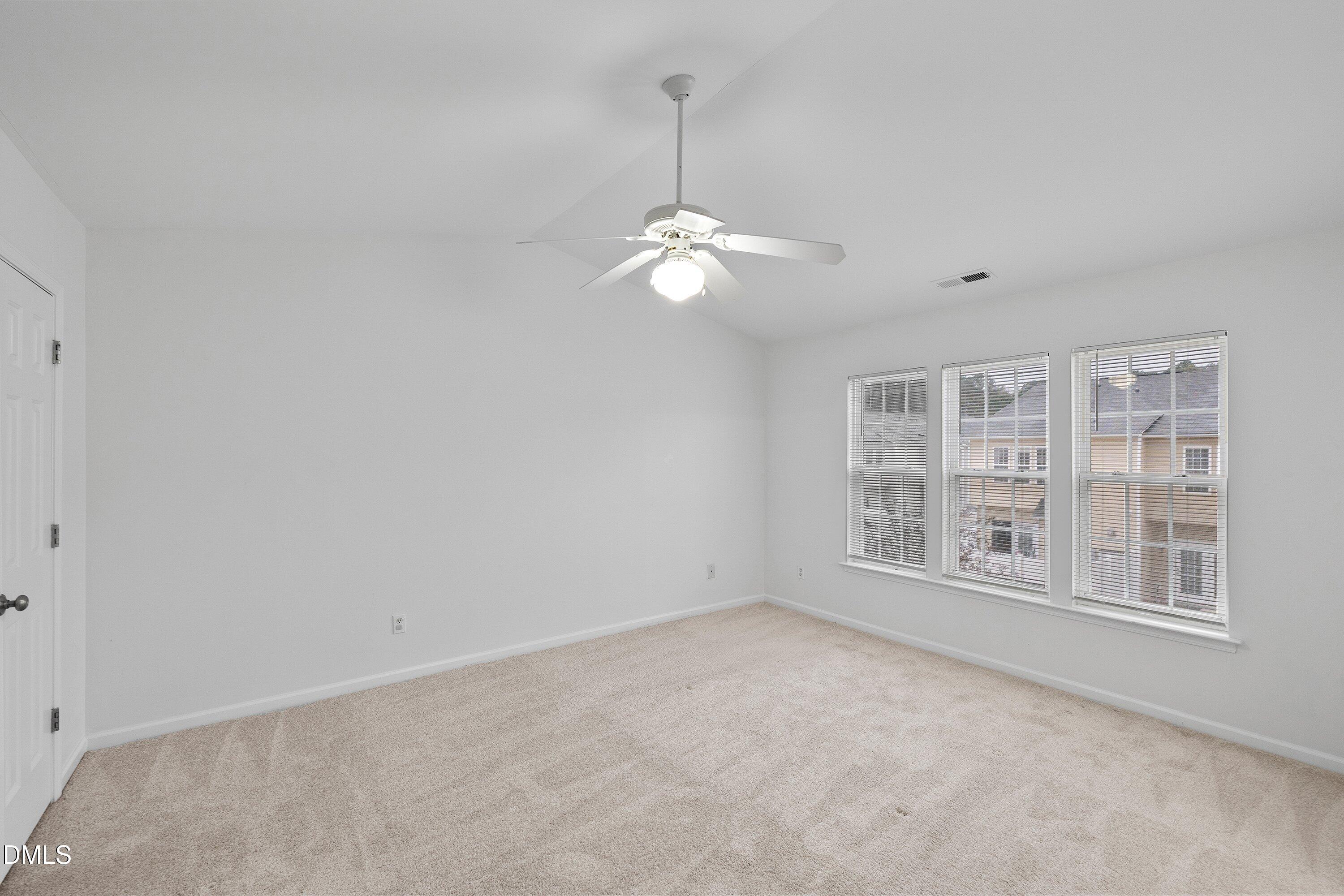 8321 Glenwood Springs Court Raleigh, NC 27616 - Photo 20 of 37 an empty room with chandelier fan and windows