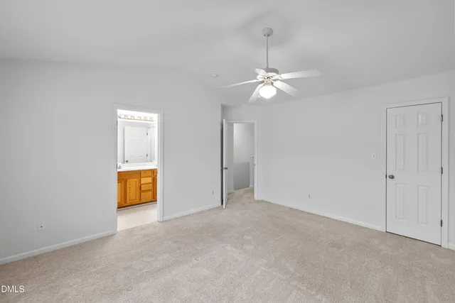 an empty room with a ceiling fan and a bathroom