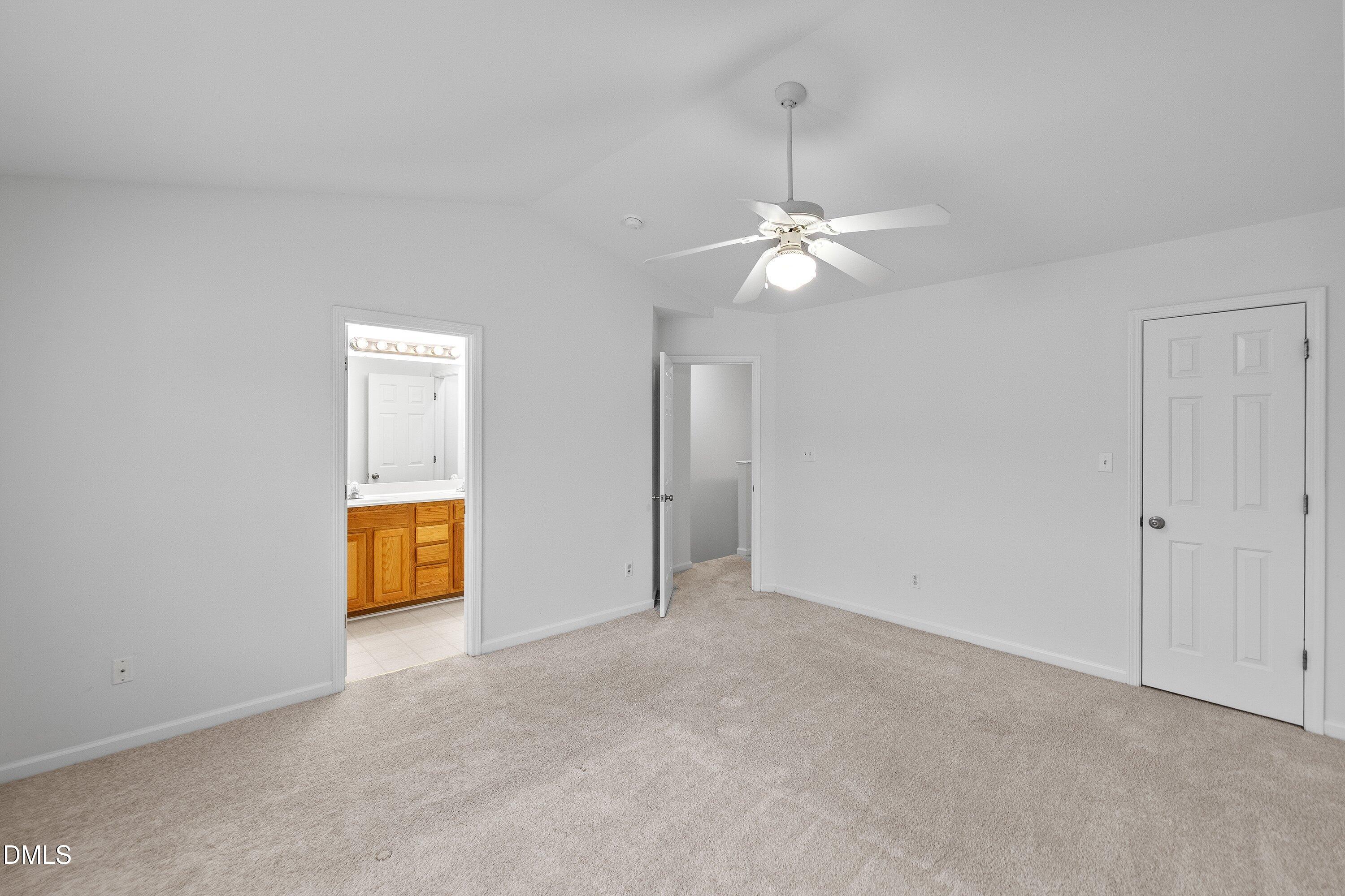8321 Glenwood Springs Court Raleigh, NC 27616 - Photo 22 of 37 an empty room with a ceiling fan and a bathroom