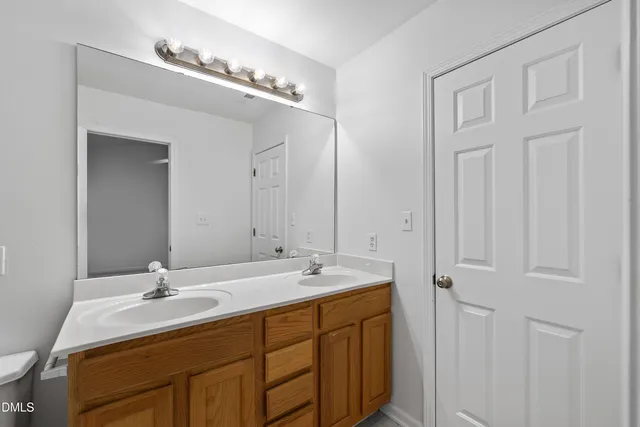 a bathroom with a double vanity sink and a mirror