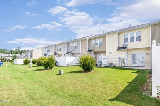 a view of a house with a big yard and a large tree