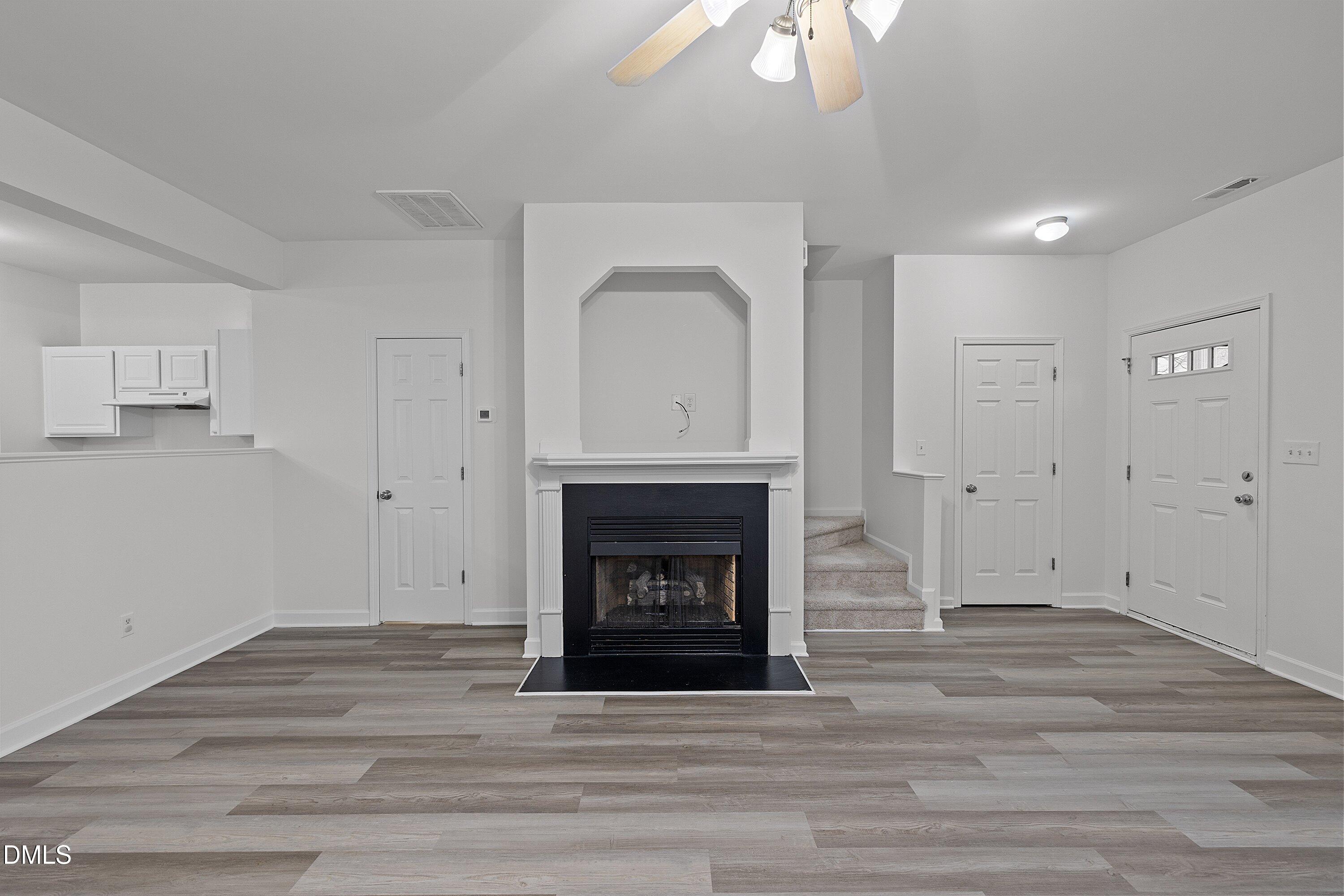 8321 Glenwood Springs Court Raleigh, NC 27616 - Photo 9 of 37 a view of an empty room with wooden floor and fireplace