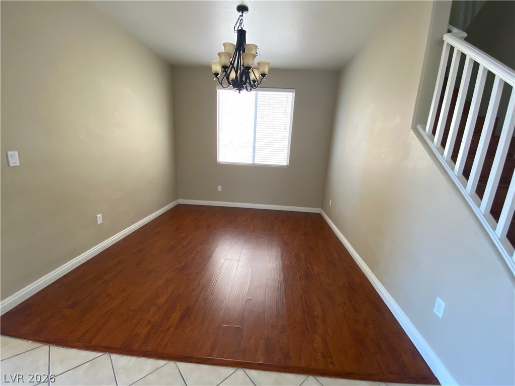 489 Foster Springs Road Las Vegas, NV 89148 - Photo 8 of 30 A well-lit room featuring rich hardwood flooring and a stylish overhead chandelier.