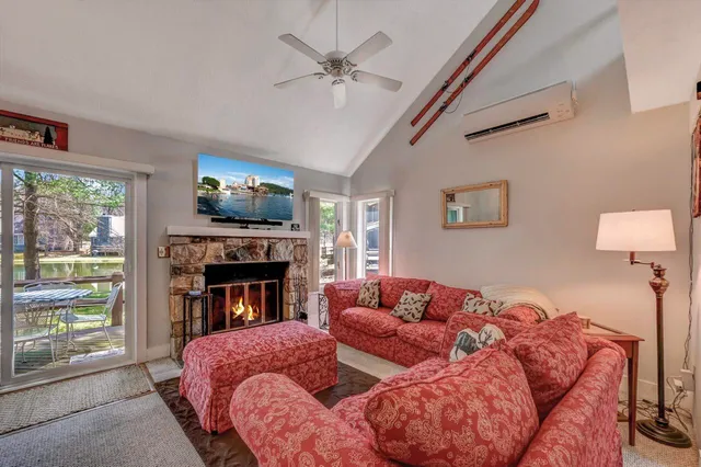 a living room with furniture a chandelier and kitchen view