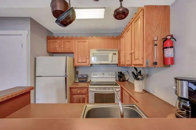 a kitchen with stainless steel appliances granite countertop a sink a stove and a refrigerator
