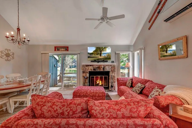 a living room with furniture a chandelier and a flat screen tv