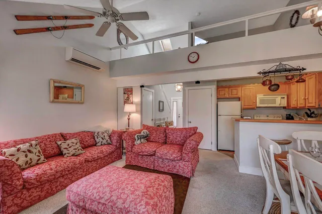 a living room with furniture a fireplace and a chandelier
