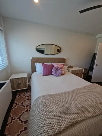 a bedroom with a bed and a flat tv screen on dresser