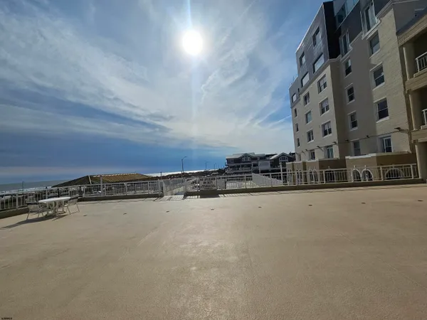 a view of swimming pool with outdoor seating and house in the background