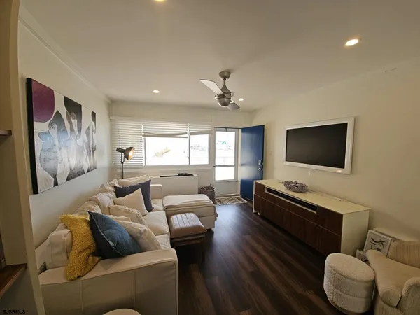 a living room with furniture and a view of kitchen