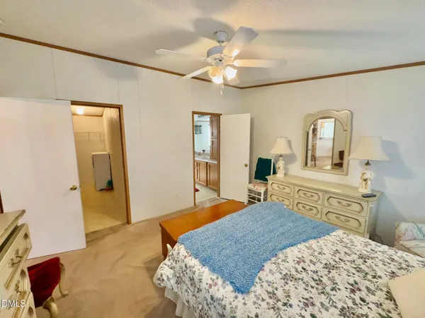 a bedroom with a large bed and a chandelier