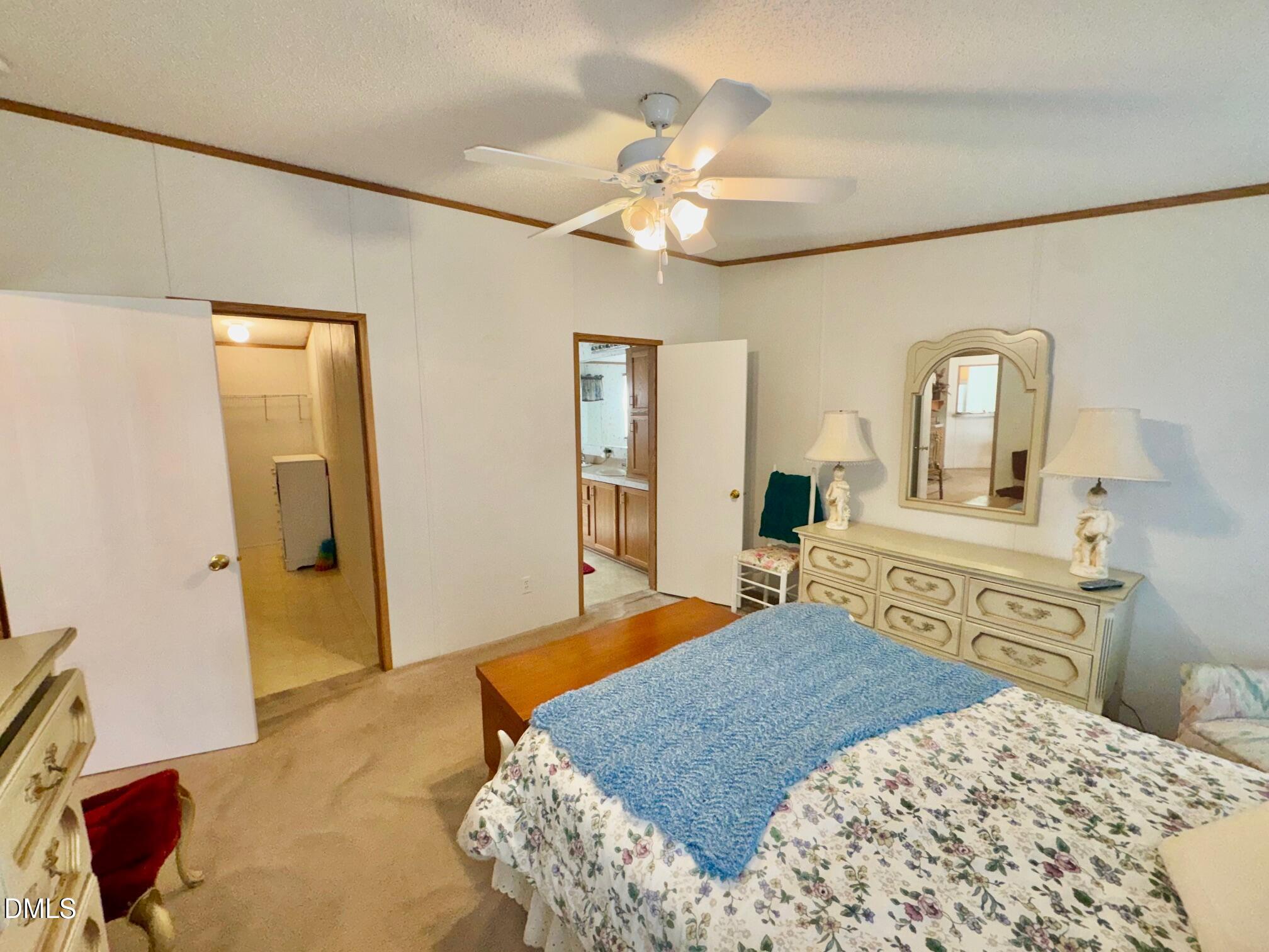 1595 Spring Valley Lake Road Henderson, NC 27537 - Photo 11 of 27 a bedroom with a large bed and a chandelier