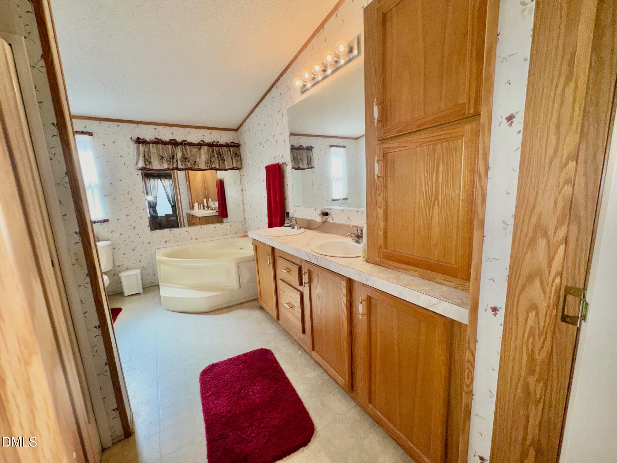1595 Spring Valley Lake Road Henderson, NC 27537 - Photo 14 of 27 a bathroom with a tub sink toilet and mirror