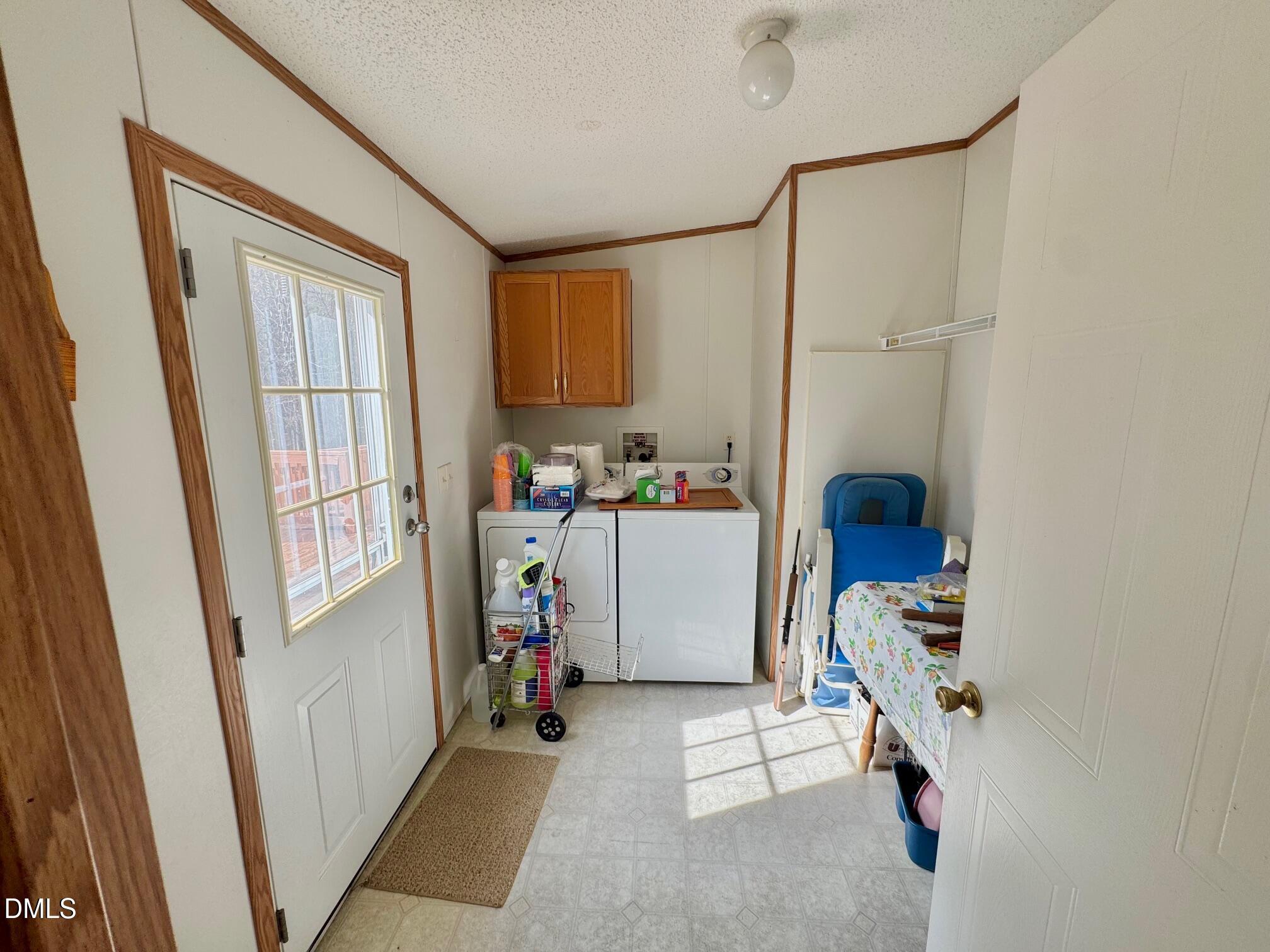 1595 Spring Valley Lake Road Henderson, NC 27537 - Photo 19 of 27 a room with furniture a washer and dryer with wooden floor