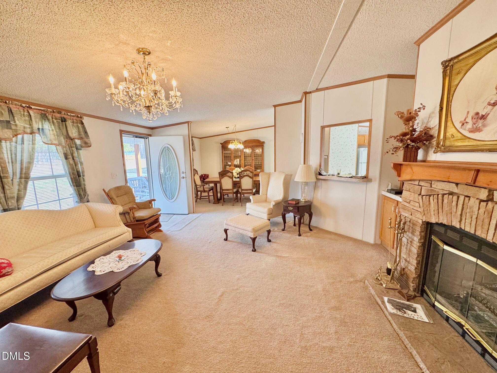 1595 Spring Valley Lake Road Henderson, NC 27537 - Photo 5 of 27 a room with chandelier furniture and a flat screen tv