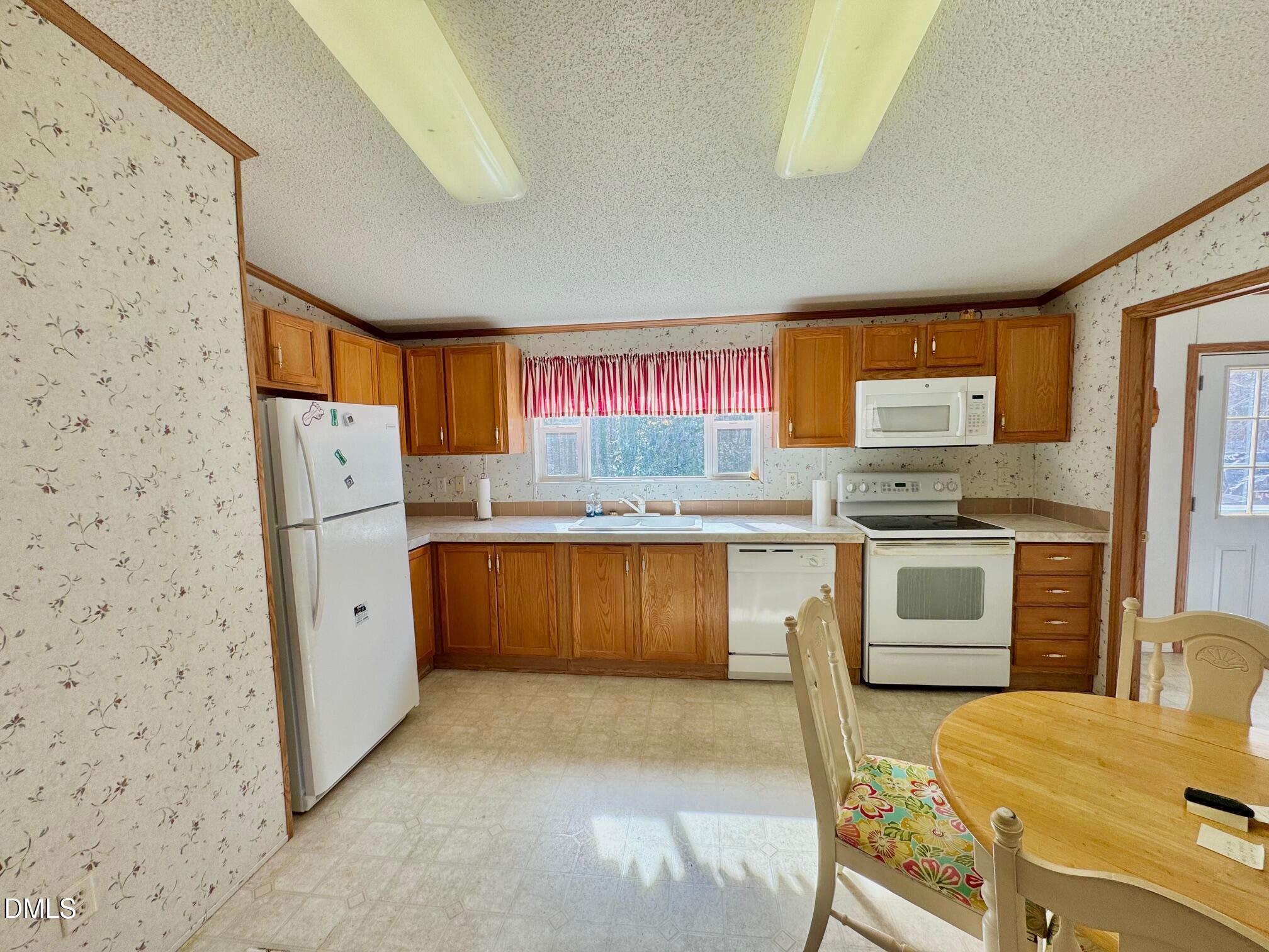 1595 Spring Valley Lake Road Henderson, NC 27537 - Photo 7 of 27 a kitchen with stainless steel appliances a stove a refrigerator and a cabinets