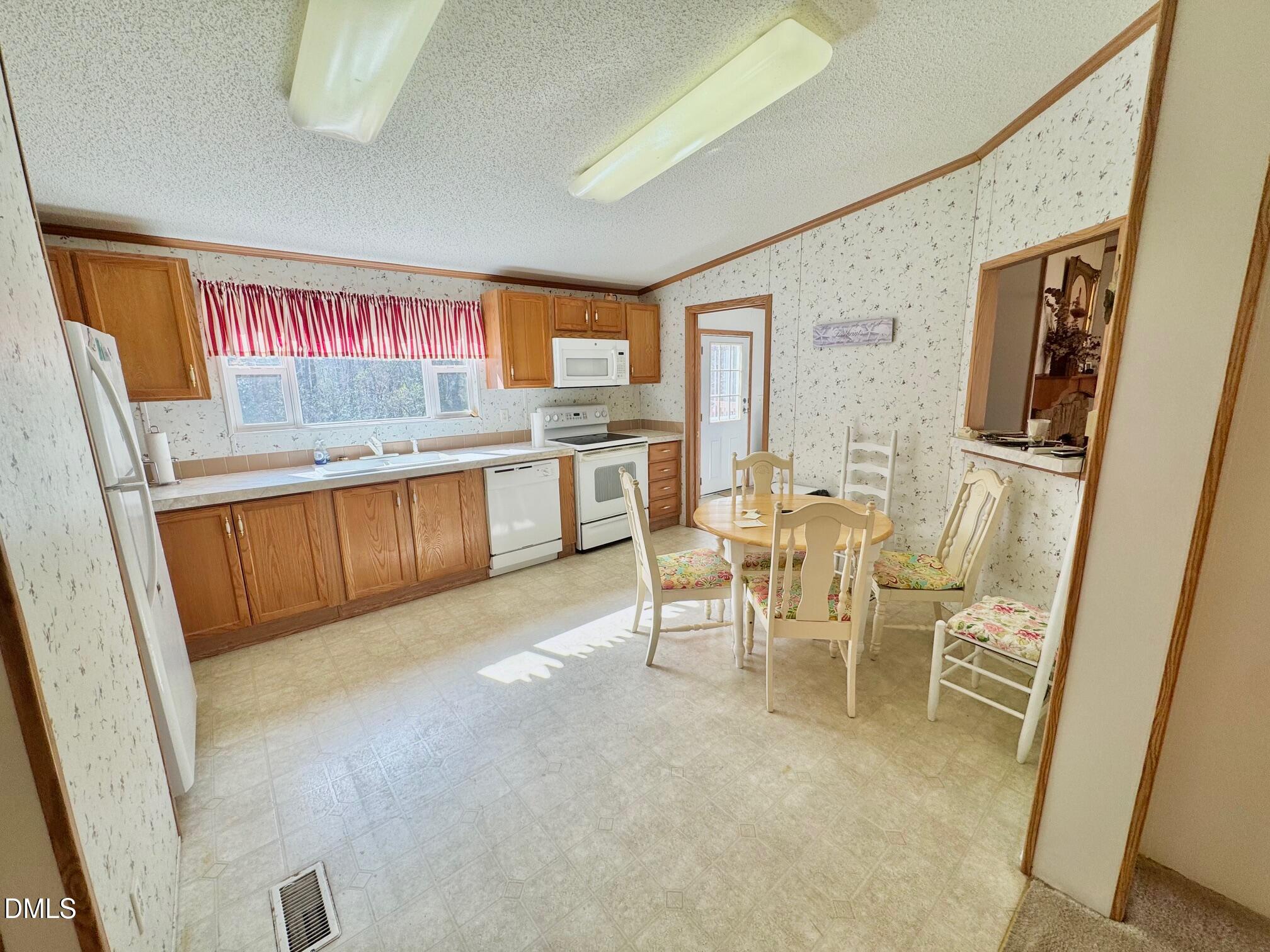 1595 Spring Valley Lake Road Henderson, NC 27537 - Photo 8 of 27 a view of a kitchen with stainless steel appliances granite countertop furniture a refrigerator and a sink