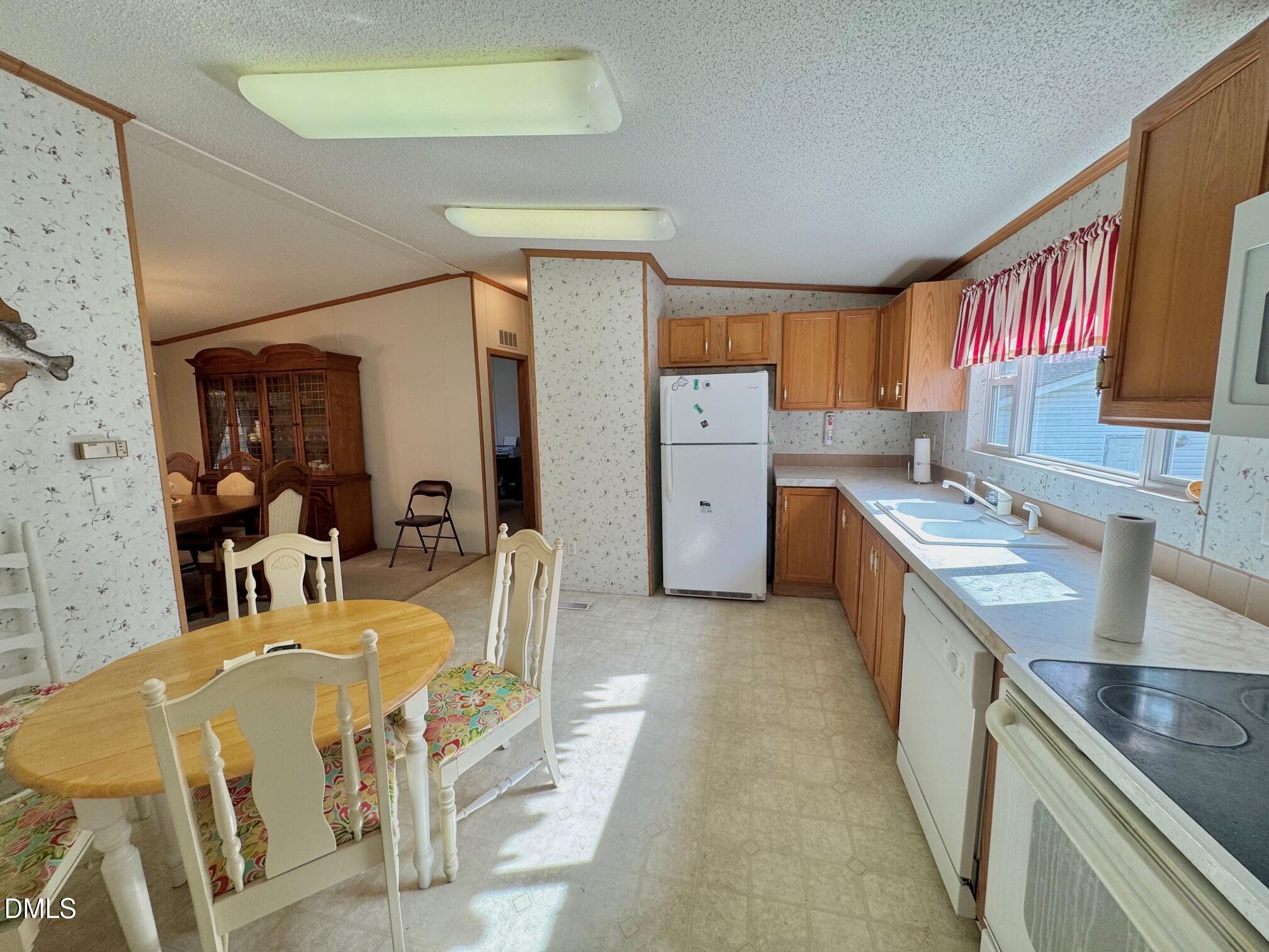1595 Spring Valley Lake Road Henderson, NC 27537 - Photo 9 of 27 a large kitchen with stainless steel appliances kitchen island granite countertop a sink and cabinets