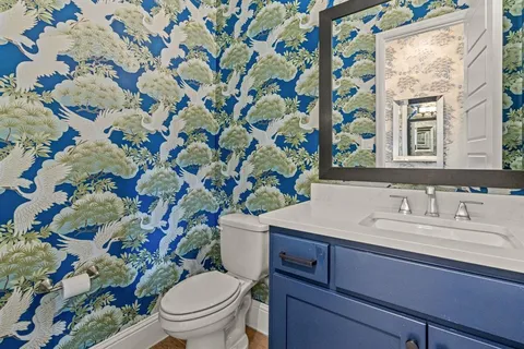 a bathroom with a sink mirror vanity and toilet