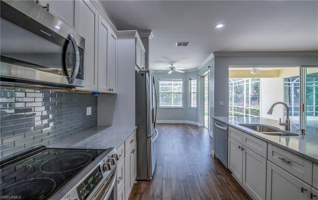 9229 Lanthorn Way Estero, FL 33928 - Photo 12 of 41 a kitchen with kitchen island granite countertop a sink stainless steel appliances and cabinets