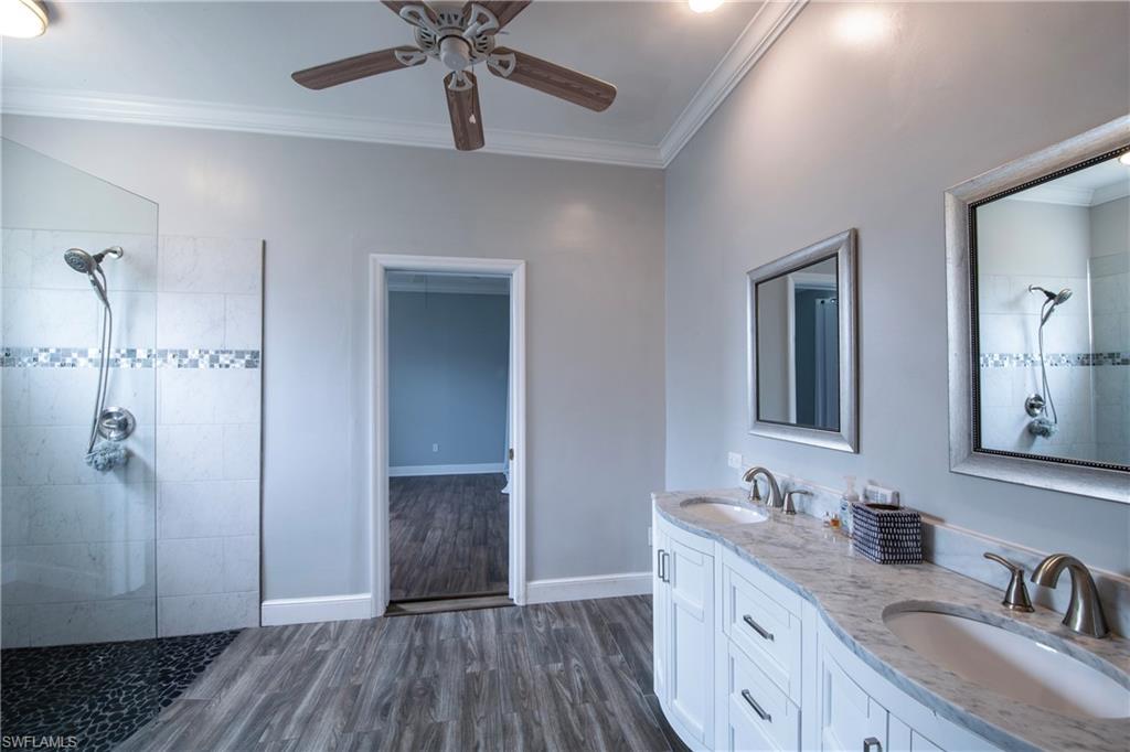 9229 Lanthorn Way Estero, FL 33928 - Photo 20 of 41 a bathroom with a double vanity sink a mirror and shower