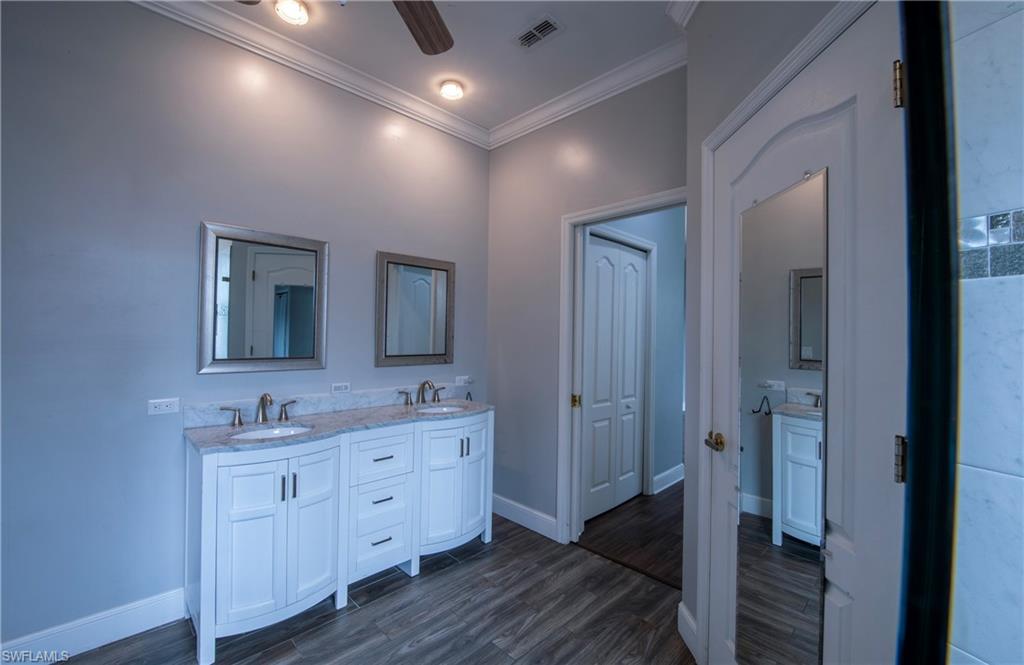 9229 Lanthorn Way Estero, FL 33928 - Photo 21 of 41 a spacious bathroom with a double vanity sink and a mirror