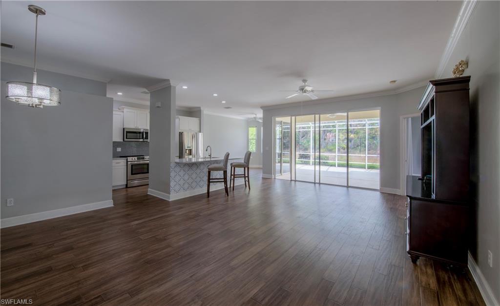 9229 Lanthorn Way Estero, FL 33928 - Photo 4 of 41 an empty room with wooden floor and windows