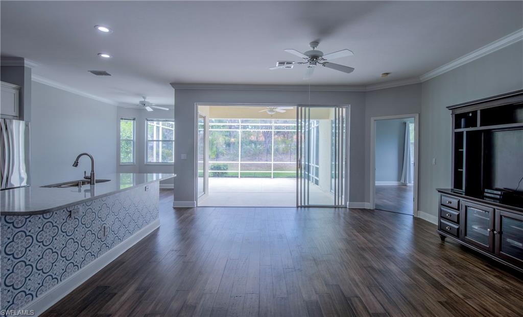 9229 Lanthorn Way Estero, FL 33928 - Photo 5 of 41 a large living room with stainless steel appliances granite countertop a couch wooden floor and a large window