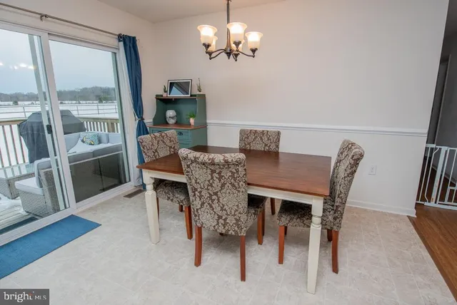 a view of a dining room with furniture a chandelier and wooden floor
